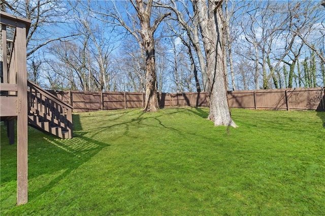 view of yard with stairs and a fenced backyard