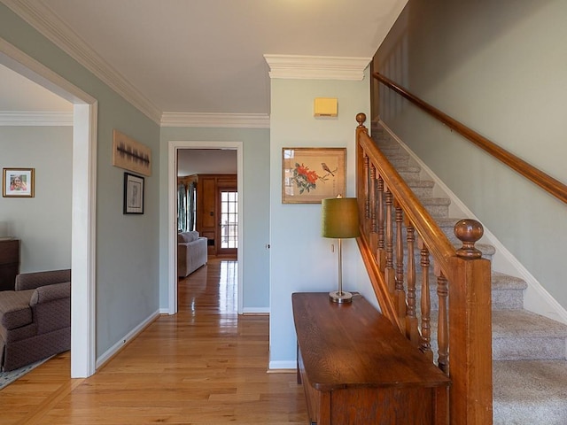 interior space with stairs, baseboards, light wood-style flooring, and crown molding