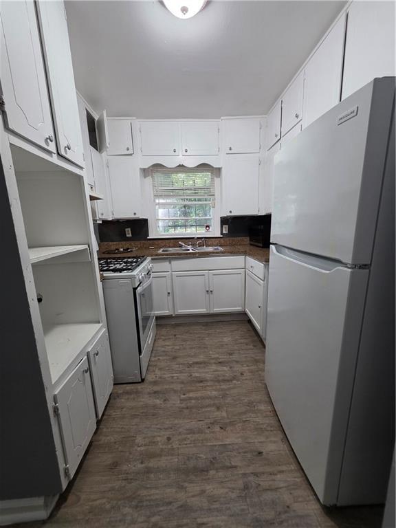 2802 3rd Ave SW, Atlanta, GA 30315 - kitchen featuring white appliances, dark wood-style flooring, white cabinets, and dark countertops