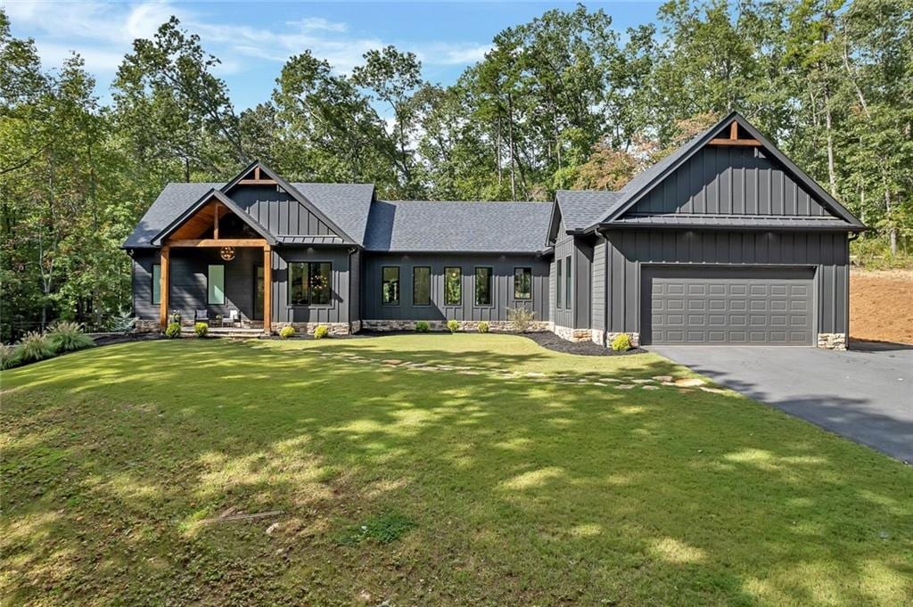 modern farmhouse with a front lawn and a garage