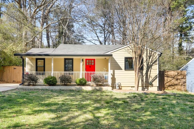 ranch-style home with covered porch, a front yard, and fence