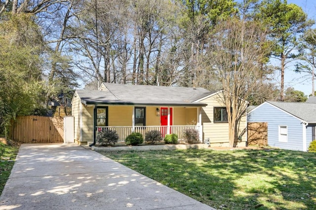 ranch-style house featuring a porch, a front yard, concrete driveway, and a gate