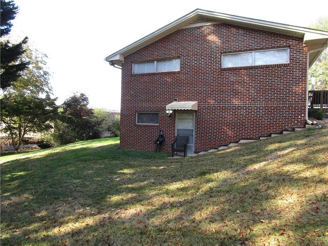 view of side of home with a yard