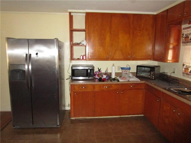 kitchen featuring dark tile patterned floors, stainless steel appliances, and ornamental molding