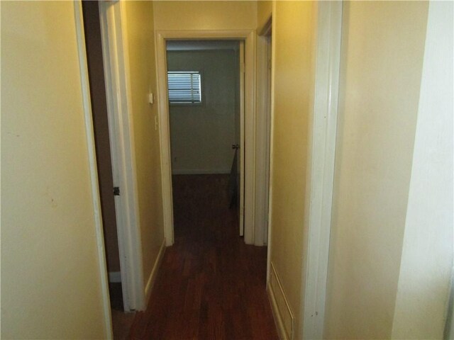 hallway with dark hardwood / wood-style flooring