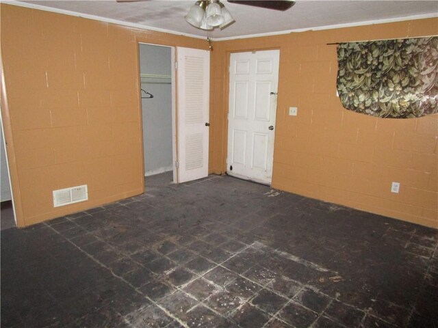 interior space with ceiling fan, crown molding, and a closet