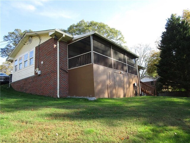 view of side of home with a lawn and a sunroom