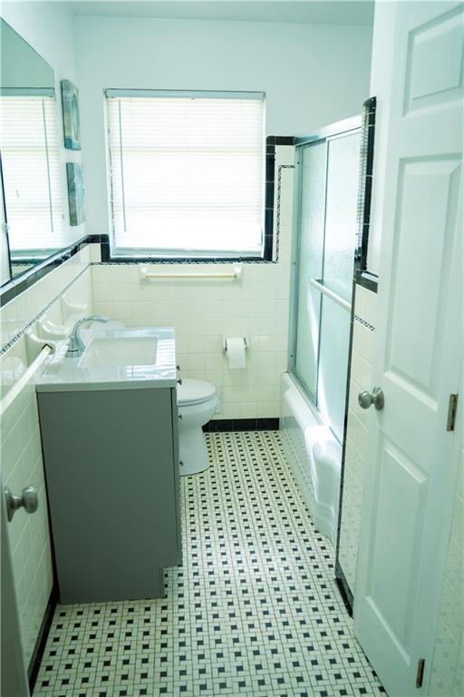 991 Lakemont Dr, Gainesville, GA 30501 - full bath featuring tile walls, vanity, toilet, tile patterned flooring, and combined bath / shower with glass door