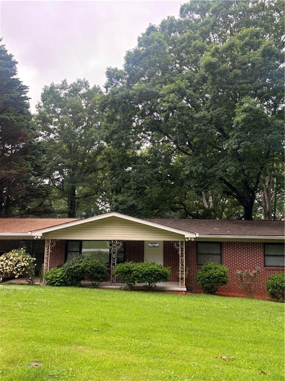 991 Lakemont Dr, Gainesville, GA 30501 - view of front facade featuring a front yard, brick siding, and a carport