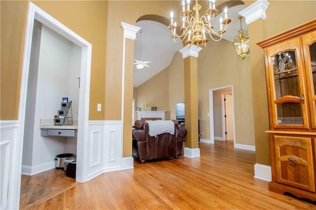 interior space featuring light wood finished floors, high vaulted ceiling, ornate columns, arched walkways, and ceiling fan