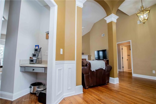 interior space with visible vents, light wood finished floors, arched walkways, and ornate columns