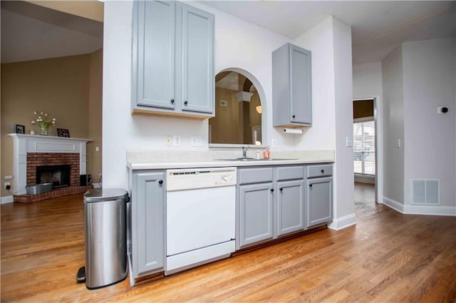 kitchen featuring a sink, visible vents, gray cabinetry, and white dishwasher