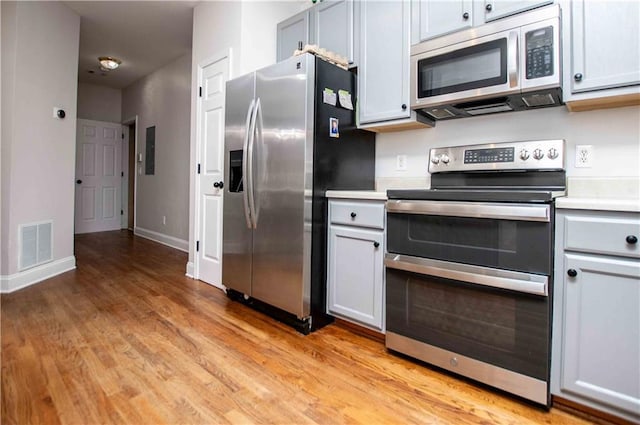 kitchen with visible vents, baseboards, light countertops, light wood-style floors, and appliances with stainless steel finishes