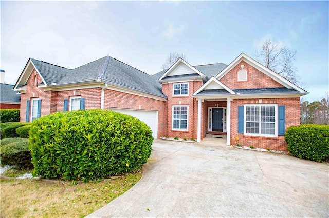 view of front facade with brick siding, driveway, an attached garage, and a shingled roof