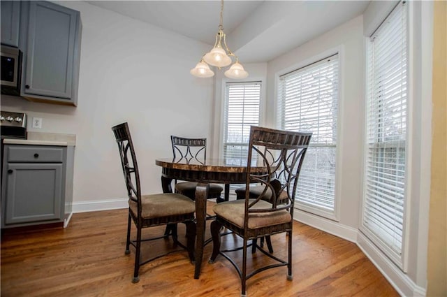 dining space featuring light wood finished floors and baseboards