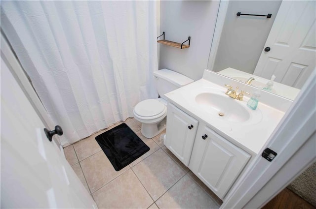 bathroom featuring tile patterned flooring, toilet, and vanity