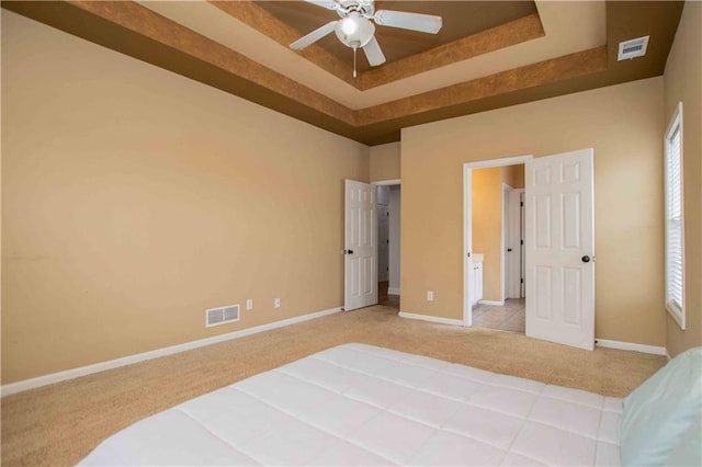 bedroom featuring visible vents, a raised ceiling, baseboards, and carpet flooring