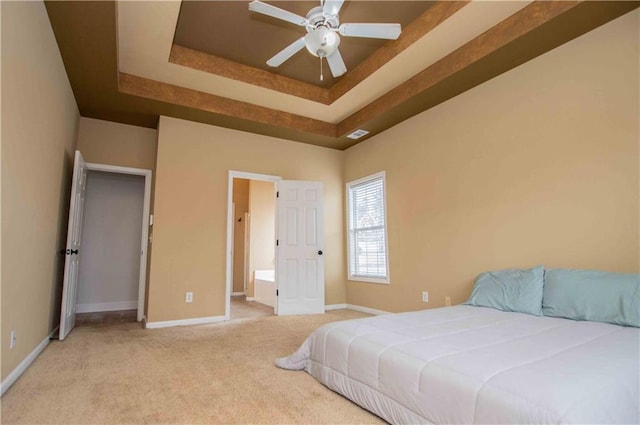 bedroom with a tray ceiling, carpet flooring, visible vents, and baseboards