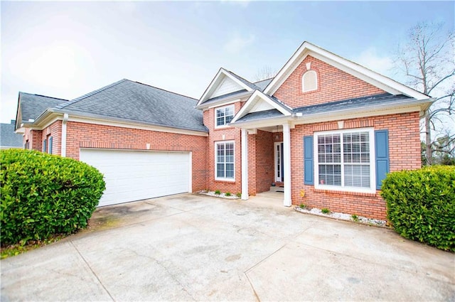 view of front of home with brick siding, a garage, driveway, and roof with shingles