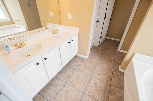 full bathroom featuring a sink, baseboards, a garden tub, and tile patterned floors