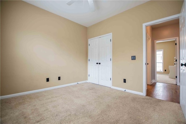 unfurnished bedroom with a closet, carpet flooring, a ceiling fan, and baseboards