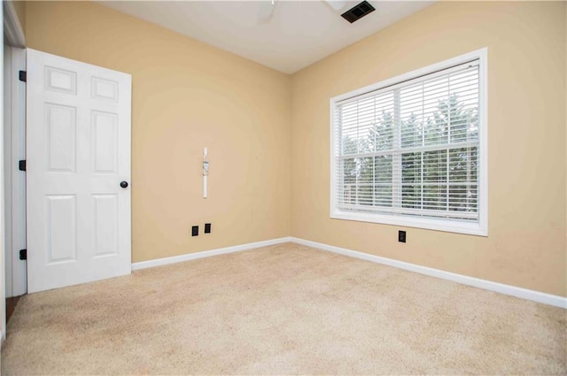 spare room featuring visible vents, a ceiling fan, baseboards, and carpet floors