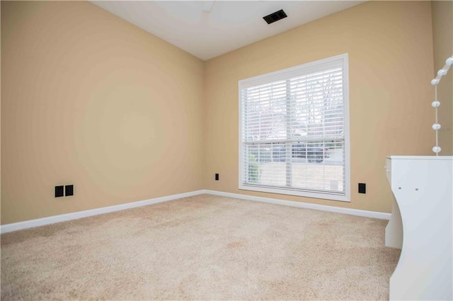 empty room featuring visible vents, baseboards, and carpet