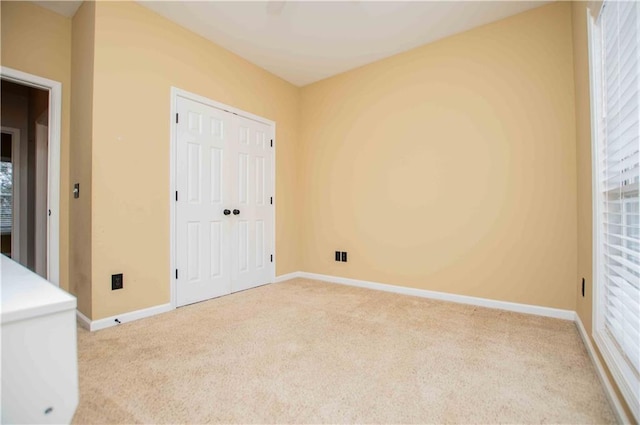 unfurnished bedroom with a closet, baseboards, and carpet floors