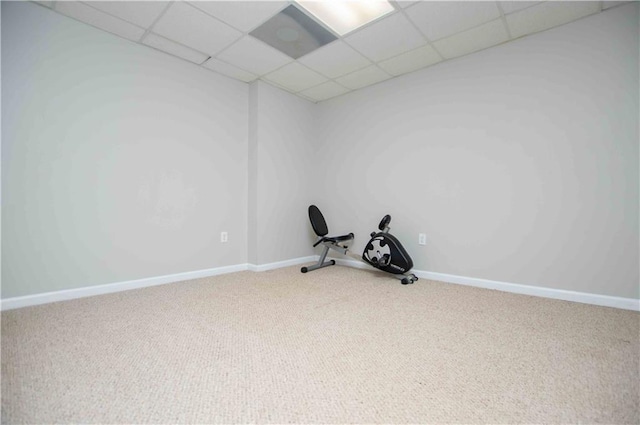 exercise area featuring a drop ceiling, baseboards, and carpet