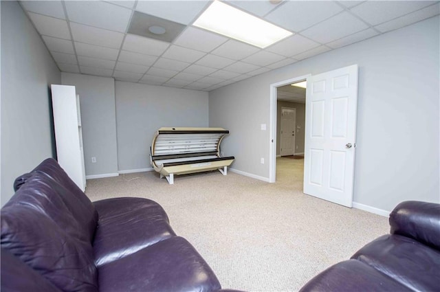 carpeted living room featuring a paneled ceiling and baseboards