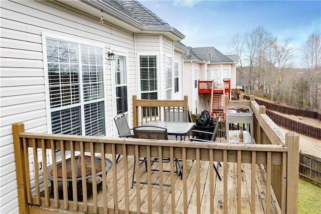 deck with outdoor dining space, stairway, and an outdoor fire pit