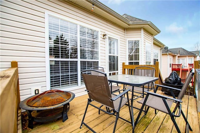 wooden terrace featuring a fire pit and outdoor dining area