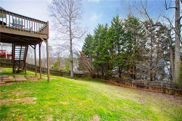 view of yard featuring a fenced backyard, stairway, and a deck