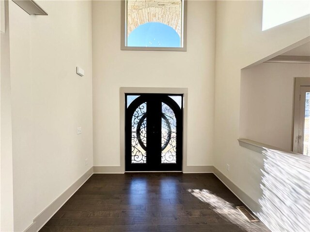 foyer entrance with dark hardwood / wood-style floors and a chandelier