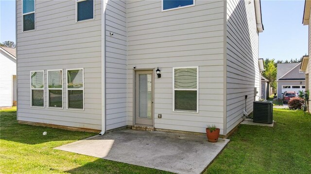 back of house with a patio area, a lawn, and central AC unit