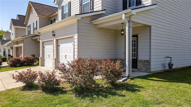view of property exterior featuring an attached garage, concrete driveway, and a lawn