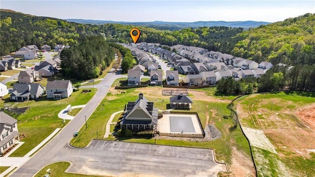aerial view of property's location with nearby suburban area and a heavily wooded area