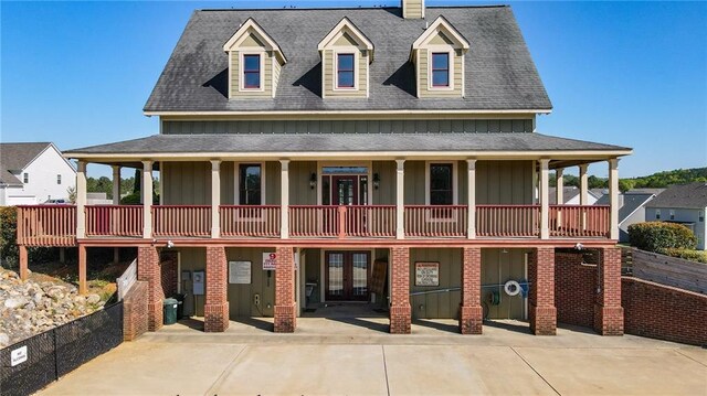 view of front of home with french doors, board and batten siding, a shingled roof, and a chimney