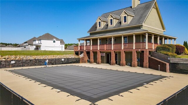 back of property featuring brick siding, a chimney, fence, and a patio area