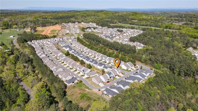 view of property location with a heavily wooded area and nearby suburban area
