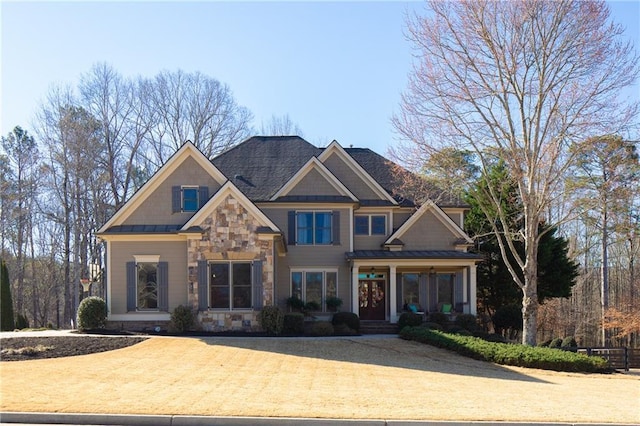 craftsman-style home featuring a standing seam roof, stone siding, and metal roof