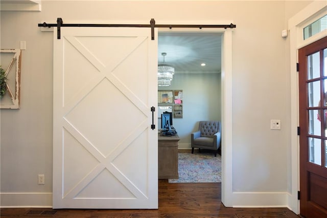 entryway with dark wood-style floors, a barn door, visible vents, and baseboards