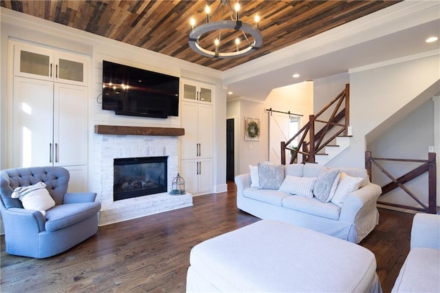 living area with a barn door, dark wood-style flooring, wooden ceiling, and a glass covered fireplace