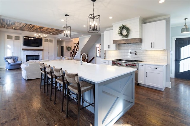 kitchen featuring pendant lighting, white cabinetry, light countertops, and open floor plan