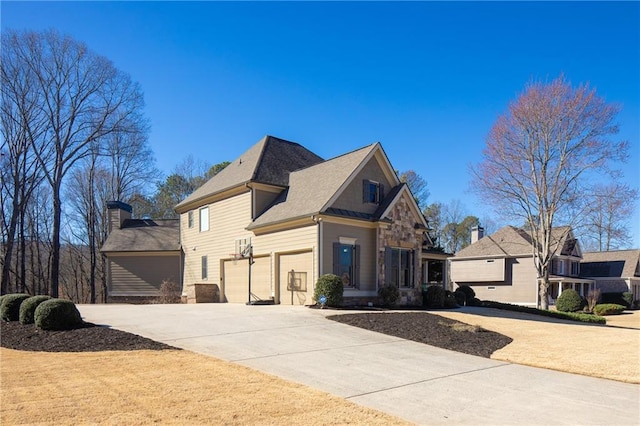 view of front facade with a garage, stone siding, and concrete driveway