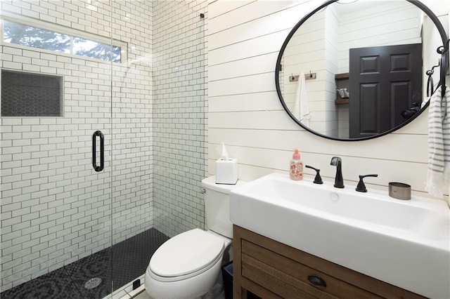 bathroom featuring wooden walls, a stall shower, vanity, and toilet