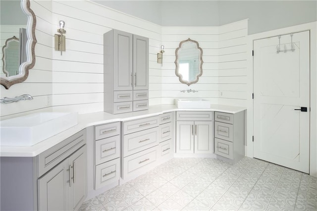 bathroom featuring wooden walls, vanity, and tile patterned floors