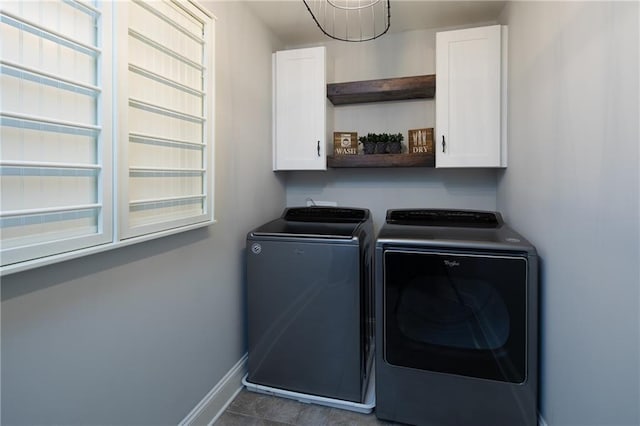 laundry area featuring a healthy amount of sunlight, washer and clothes dryer, cabinet space, and baseboards