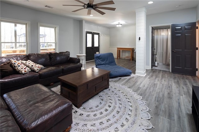 living room featuring light wood-style flooring, recessed lighting, visible vents, baseboards, and decorative columns