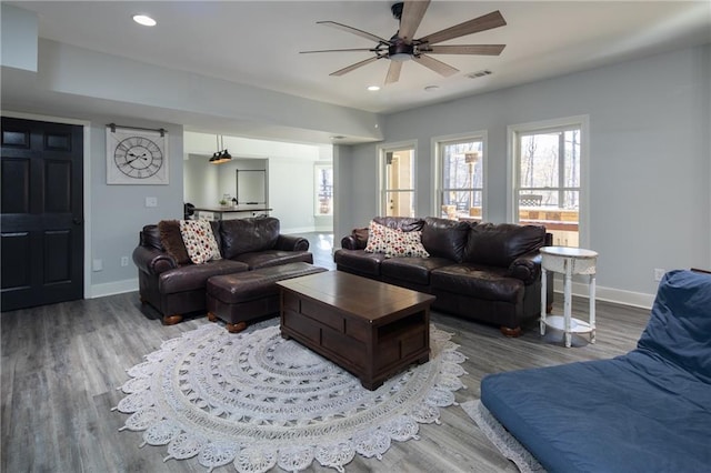 living area with recessed lighting, wood finished floors, visible vents, and baseboards